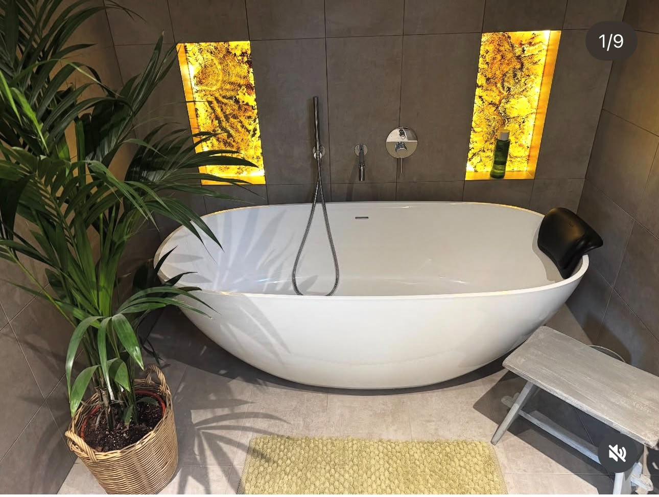 Freestanding bath installation with illuminated wall niches in a finished bathroom