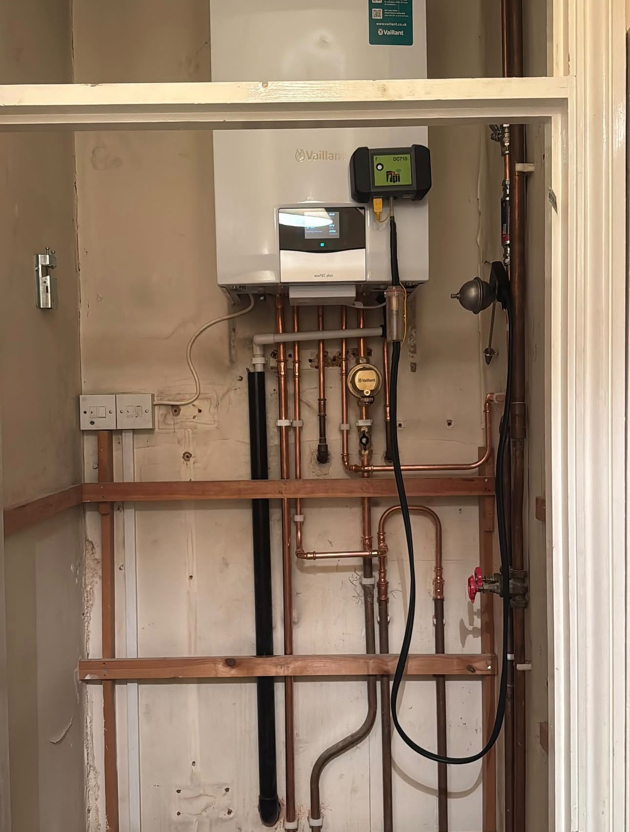 Vaillant boiler installation in a service cupboard with diagnostic equipment attached