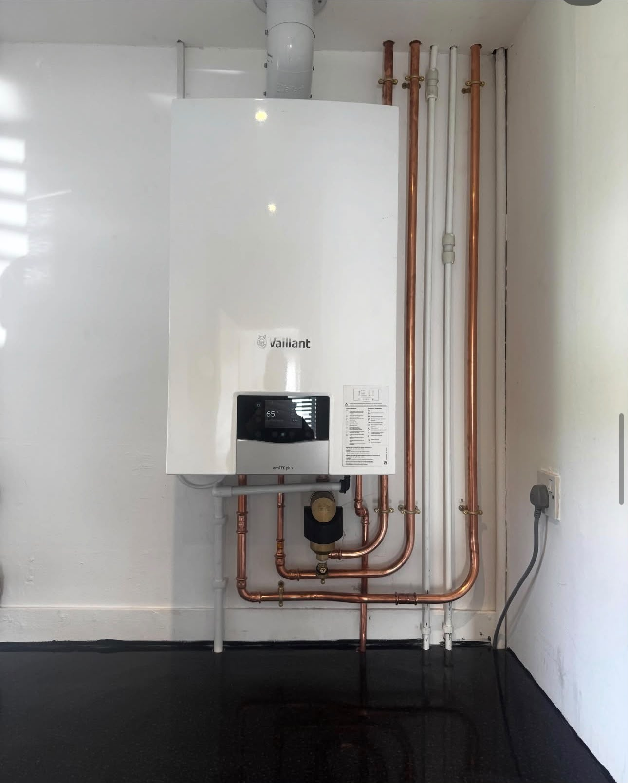Gas Safe engineer installing a wall-mounted combi boiler